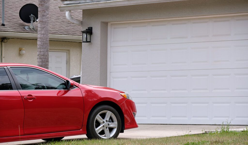 photo of a car in the driveway of a home