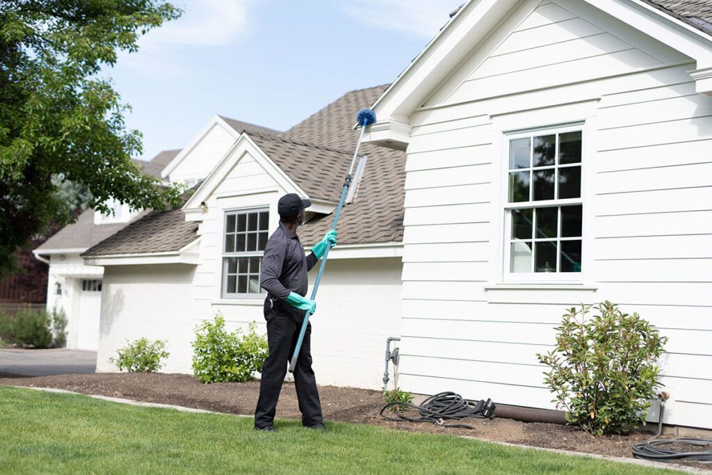 photo of a Hawx pest control technician treating the outside of a hom